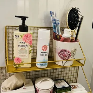 a bathroom shelf with soap, toothbrushes, and other items