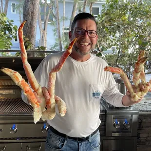 a man holding crab legs