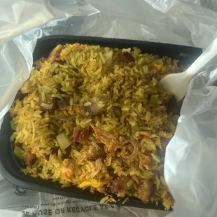 a tray of rice with a spoon in it