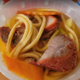 a bowl of noodles with meat and vegetables
