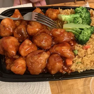 A staple right on top of her Orange Chicken