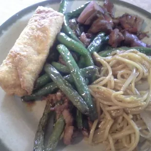 Tasty green beans and pork with teriyaki chicken, noodles, and an egg roll.