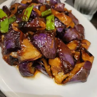 a plate of chinese food with chopsticks