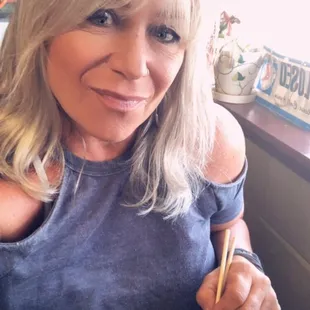 a woman holding chopsticks and a plate of food