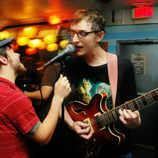 two young men singing and playing guitar