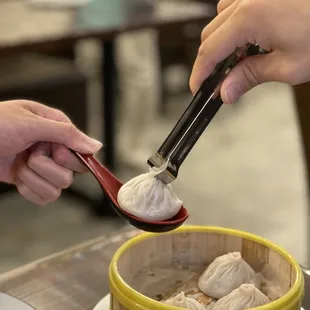 a person scooping dumplings out of a bowl