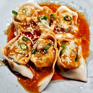 a plate of dumplings with sauce