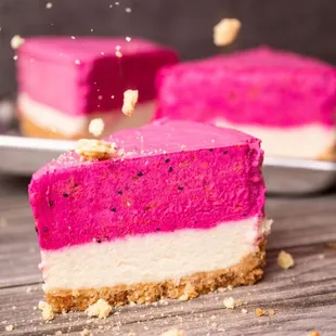 a slice of cake with pink and white frosting