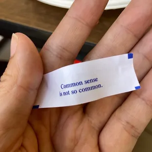 a hand holding a piece of paper that says common sense is not so common