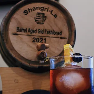 a drink in a glass next to a barrel