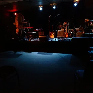 a stage with a guitar, drums, and other musical equipment