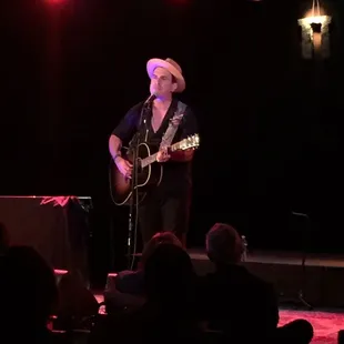 a man playing a guitar on stage