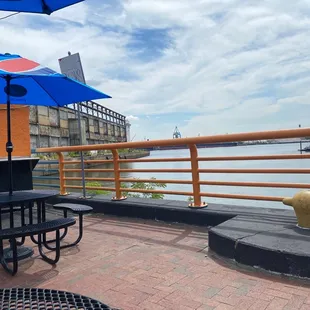 a table and chairs on a patio overlooking the water