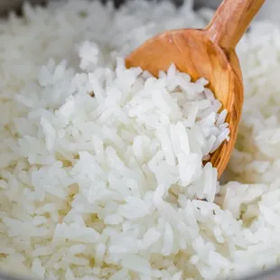 a bowl of rice with a wooden spoon
