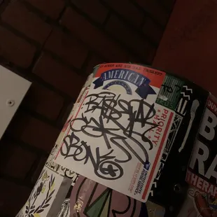 a trash can with stickers on it