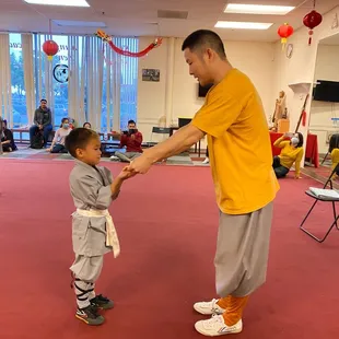 Shifu Yanwen Shi handing Bensen his yellow belt