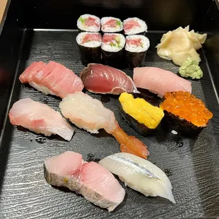 a variety of sushi on a black tray