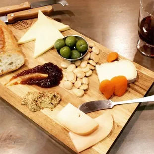 cheese, olives, and bread on a cutting board