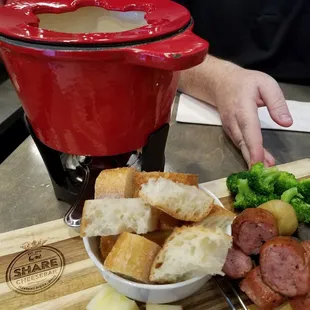 Fondue night includes bread, sausage, potatoes, apples and broccoli.