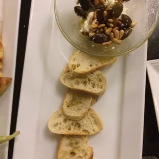 Crostini warm goat cheese with calmati olives and pine nuts