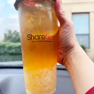 a person holding a cup of iced tea
