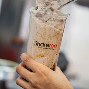 a hand holding a cup of ice cream