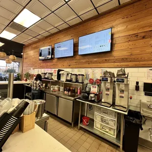 a restaurant with a counter and tvs