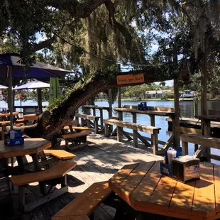 a dock with picnic tables and umbrellas
