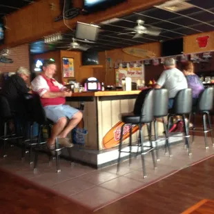 Large bar area with high tops and game room in the background