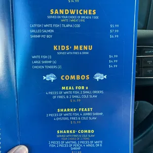 a hand holding a menu in a car