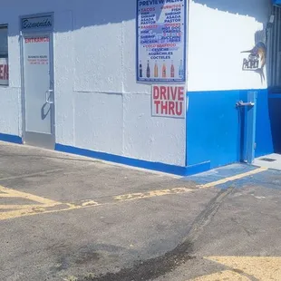 an empty parking lot with a blue and white building
