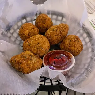 a basket of fried meatballs with ketchup