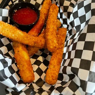 Cheese sticks with golden hot wing sauce on the side