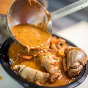 a spoon full of sauce being lifted from a skillet