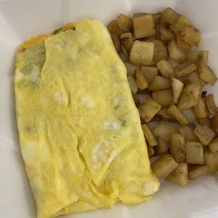 Veggie omelette and home fries. Omelet has fresh spinach and mushrooms, cheese, tomatoes, onions and green peppers
