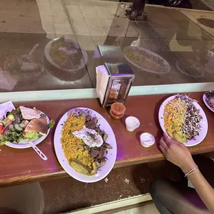 Gyro platter with starter salad in left and beef shawarma platter with started salad on the right with sauces in the middle :)