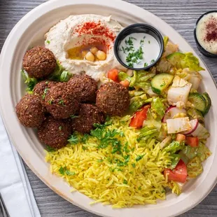 Falafel Plate- Falafel rice, salad, hummus, and fresh baked bread. including our tahini, garlic, and chili sauce.