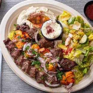 Premium Plate- Beef, chicken, kufta  kabob over rice, salad, hummus, and fresh baked bread. including our tahini, garlic, and chili sauce.