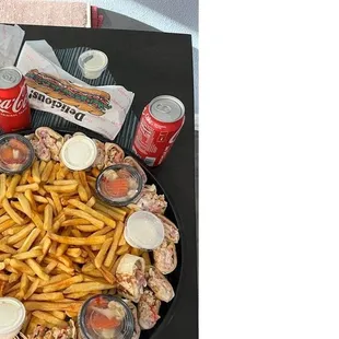 a platter of fries and sodas