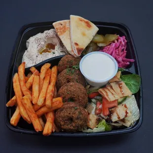 Falafel World Platter: 4 pcs falafel, Mediterranean salad (fattoush) with side pickled turnips, fries, tahini, hummus, and pita bread.