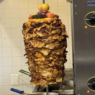 the meat being cooked on a skewer