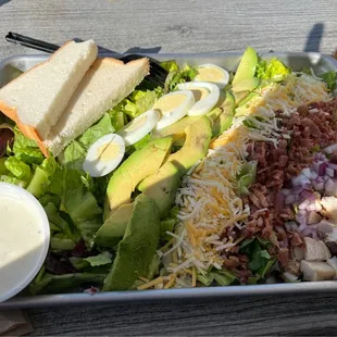 a salad with dressing and a sandwich