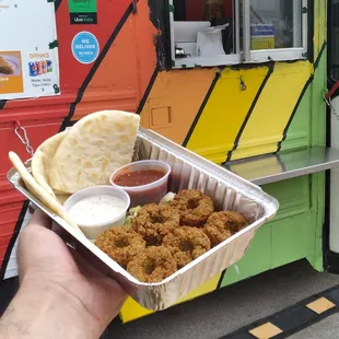 a hand holding a tray of food