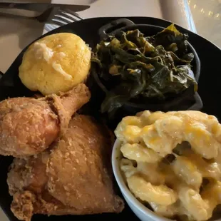 a plate of fried chicken, macaroni and cheese and greens