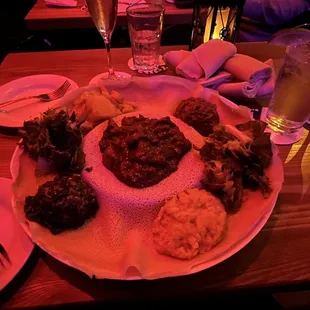 Veggie plates with beef tibs in the middle