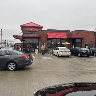 a parking lot with cars parked in front of a restaurant