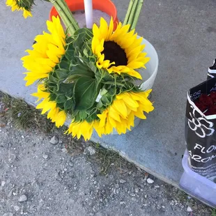 a vase of sunflowers and a bottle of soda