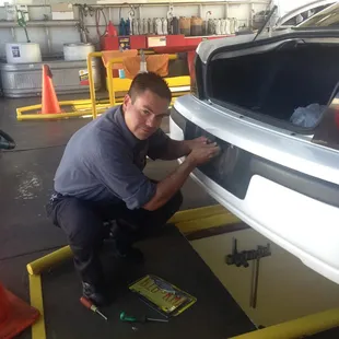 Changing a license plate bulb for a customer.