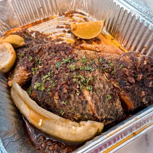 a meat dish in a foil container