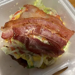 a bacon and lettuce sandwich in a styrofoam container